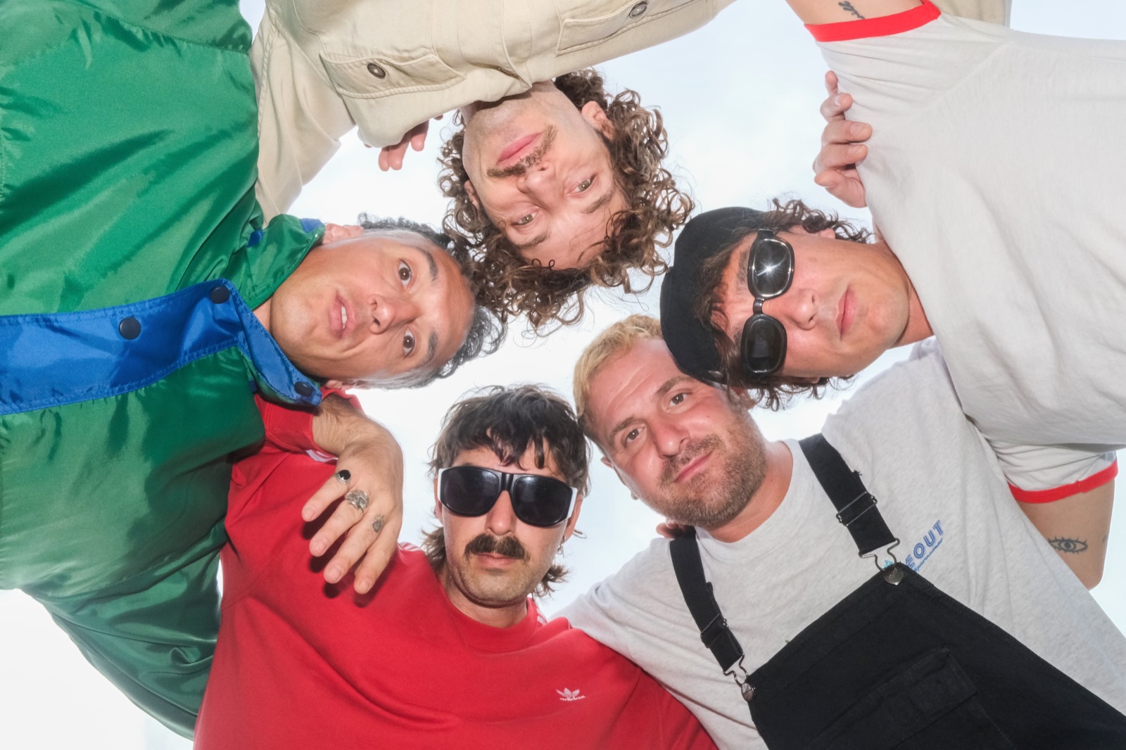 The band seen from below, heads together in a circle